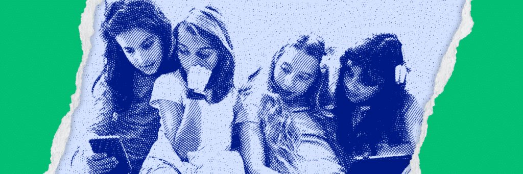 girls looking over shoulders at cell phone